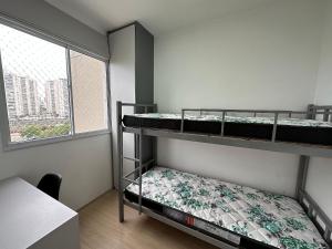 two bunk beds in a room with a window at TrevizZo Allianz Parque in Sao Paulo