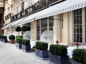 uma fila de mesas e plantas em frente a um edifício em Haymarket Hotel, Firmdale Hotels em Londres