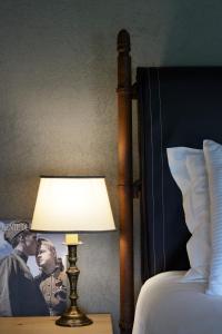 a lamp on a night stand next to a bed at Relais Rossar Boutique Hotel Garda & Hills in Costermano