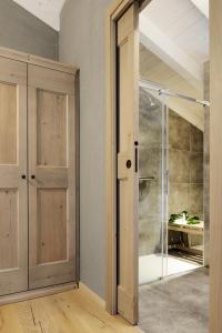 a bathroom with a shower and a glass door at Relais Rossar Boutique Hotel Garda & Hills in Costermano