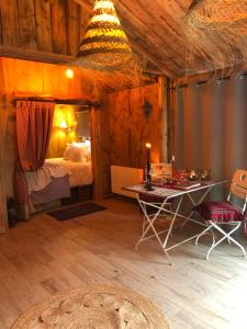 ein Schlafzimmer mit einem Tisch und einem Bett in einem Zimmer in der Unterkunft Au Bien-Etre à Deux in Spa