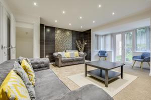 ein Wohnzimmer mit einem Sofa und einem Tisch in der Unterkunft Elegant Bolton Abode - Sleeps 10 in Bolton