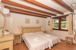 a bedroom with a bed and a desk and a window at Villa Camp del Bosch by Sealand Villas in El Port +41 photos