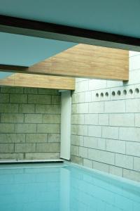 uma piscina com um tecto de madeira e uma parede de tijolos em 4 bedrooms villa with indoor pool jacuzzi and enclosed garden at Santo Tirso em Santo Tirso