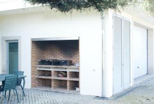 um edifício com uma parede de tijolos e um forno de pizza em 4 bedrooms villa with indoor pool jacuzzi and enclosed garden at Santo Tirso em Santo Tirso