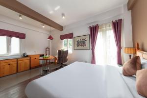 een slaapkamer met een groot bed en een tafel bij Golden Sunshine Villa Hotel and Travel in Hanoi