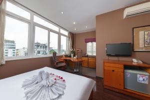 a hotel room with a bed and a television at Golden Sunshine Villa Hotel and Travel in Hanoi
