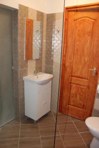 baño con lavabo y puerta de madera en Chill House, en Miskolc