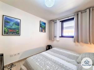 a bedroom with a bed and a window at Villa Marie France - avec jacuzzi et sauna - Plaine des Cafres in Le Tampon