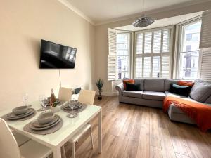 un soggiorno con divano e tavolo di Cozy Flat in South Kensington a Londra