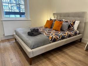 - un lit avec des oreillers dans l'établissement Cozy Flat in South Kensington, à Londres