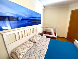 1 dormitorio con 1 cama y una pintura en la pared en Casa Chiara, roof terrace, 100m to the historical center en Lecce