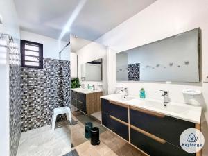 a bathroom with two sinks and a shower at Villa Marie France - avec jacuzzi et sauna - Plaine des Cafres in Le Tampon +19 photos