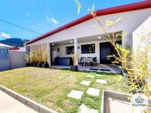 a house with a backyard with a yard at Villa Marie France - avec jacuzzi et sauna - Plaine des Cafres in Le Tampon