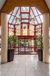 a large glass building with two potted plants at Castrum Hotel Székesfehérvár in Székesfehérvár