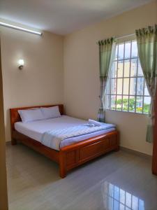 um quarto com uma cama e uma grande janela em Nhà Nghỉ KHÁNH NGỌC em Vung Tau
