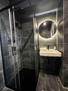 y baño con ducha, lavabo y espejo. en Stylish studio for 3 near Regent’s Park n3, en Londres