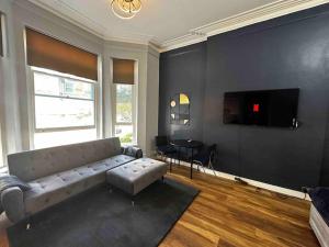 ein Wohnzimmer mit einem Sofa und einem TV in der Unterkunft Stylish studio for 3 near Regent’s Park n3 in London