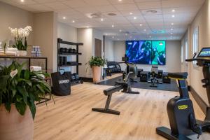 a gym with several treadmills and a flat screen tv at Novotel Nice Arenas Aeroport in Nice