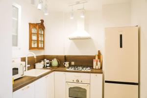 a kitchen with a stove and a white refrigerator at LHL Old City in Batumi