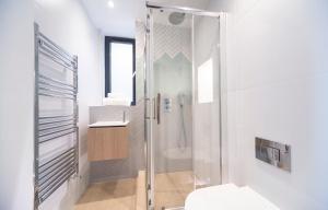a bathroom with a shower and a toilet at Bright & Quiet - Spacious Apt with Balcony & Lift in London