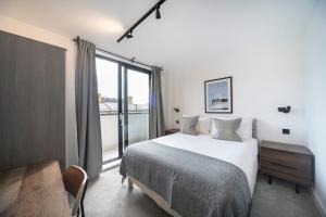sypialnia z łóżkiem i dużym oknem w obiekcie Bright & Quiet - Spacious Apt with Balcony & Lift w Londynie