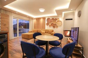 ein Wohnzimmer mit einem Sofa, einem Tisch und Stühlen in der Unterkunft Moments Apartaments Prevalle in Prevalla