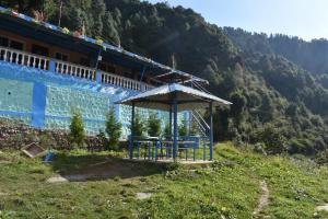 un edificio con un cenador al lado de una colina en LaCliff Nature Home, en Dhanaulti