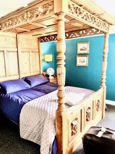 um quarto com uma cama de dossel com lençóis roxos em Park Broom Lodges - Caldew House - Eden House - Petteril House em Carlisle