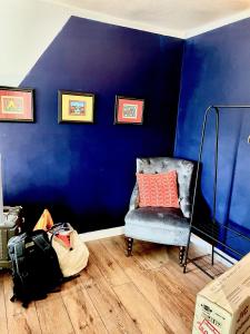 um quarto com uma parede azul com uma cadeira e uma almofada em Park Broom Lodges - Caldew House - Eden House - Petteril House em Carlisle