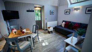 a living room with a table and a blue couch at The Lodges @ Barra Castle in Inverurie