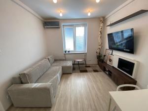 Il comprend un salon doté d'un canapé et d'une télévision à écran plat. dans l'établissement Moderný byt v centre mesta, à Nitra