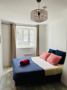 - une chambre avec un lit doté de 2 oreillers rouges dans l'établissement Jolie maison dans la ville close de concarneau, à Concarneau