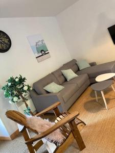 - un salon avec un canapé et une chaise dans l'établissement Jolie maison dans la ville close de concarneau, à Concarneau