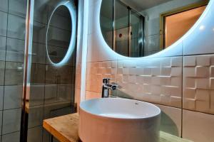 een badkamer met een wastafel en een spiegel bij Au petit Payolle - Appartement type Chalet sur le Lac de Payolle in Campan