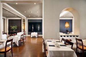 فندق كوندادو في برشلونة: غرفة طعام مع طاولات وكراسي بيضاء