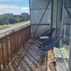 two chairs sitting on the balcony of a building at Beautiful apartment with sauna in Tallinn