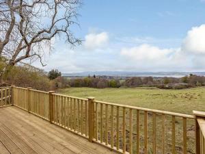 a wooden deck with a view of a field at Kilninver Chalet on Reelig Estate Near Inverness in Kirkhill