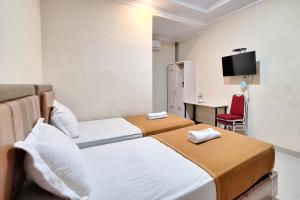 Un pat sau paturi într-o cameră la Hotel Jelita Mentawai Redpartner