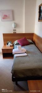 sypialnia z łóżkiem z drewnianym zagłówkiem w obiekcie Hotel Cortina w Rimini
