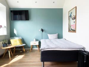 een slaapkamer met een bed met een blauwe muur bij athome apartments in Aarhus