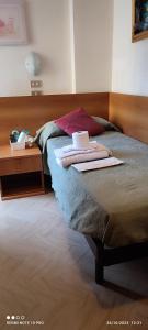 sypialnia z łóżkiem ze stołem i laptopem w obiekcie Hotel Cortina w Rimini