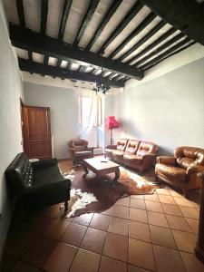 a living room with leather couches and a table at Locanda Del Duca in Gubbio