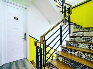 a stairway with a white door and a yellow wall at AILEN BOUTIQUE HOTEL in Ho Chi Minh City