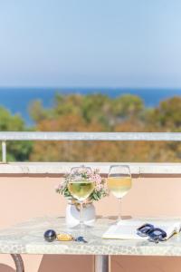 a table with two glasses of wine and a book at Hotel Naica in Rimini