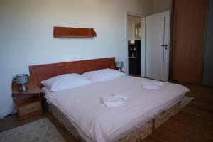 a bedroom with a large bed with two towels on it at Apartmany u Denyho in Zuberec