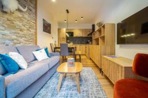 salon z niebieską kanapą i stołem w obiekcie Echo du Pleney A001 w mieście Morzine
