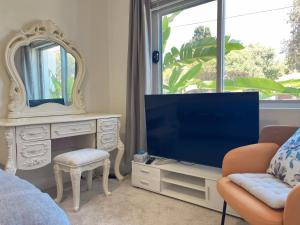 uma sala de estar com televisão e espelho em The South bay's home-Big RoomA em Sydney