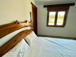a bedroom with a bed with a wooden head board at Cortijo la Noria II in Puebla de Don Fadrique