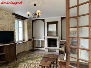 a living room with a fireplace and a tv at Clos Lussault in Lussault-sur-Loire